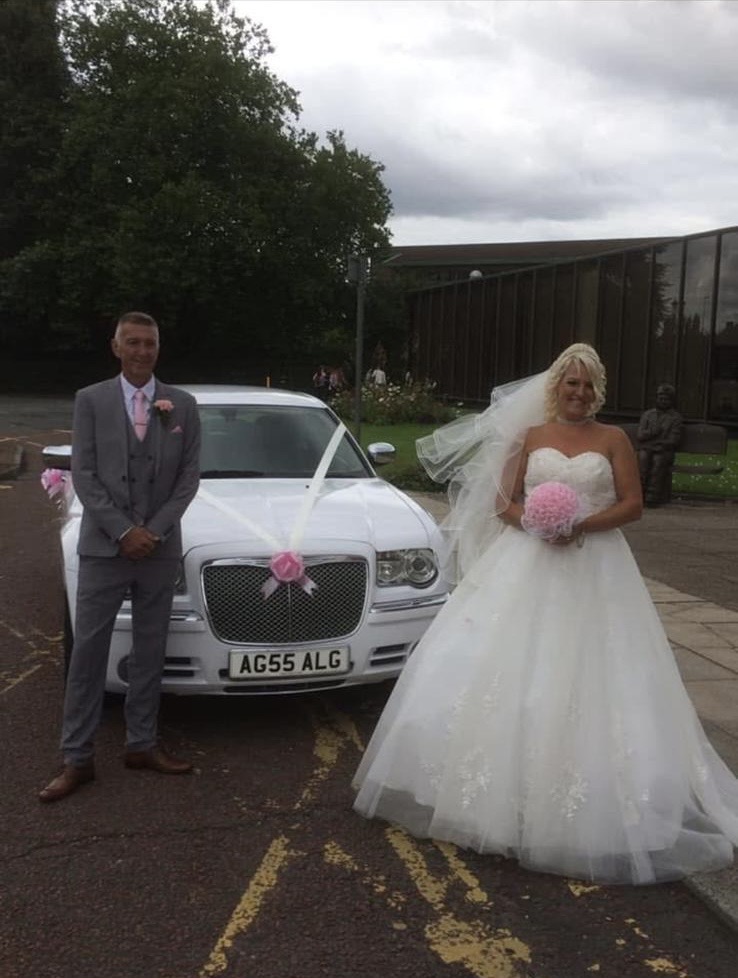 Bride and groom beside the white Baby Bentley